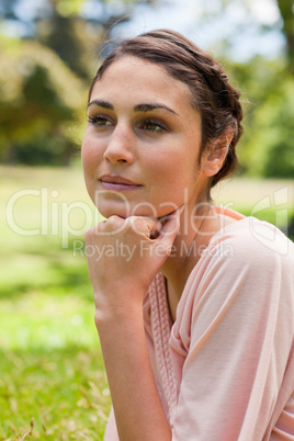 Woman looking into the distance while resting her head on her fi