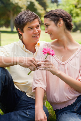 Man giving a flower to a woman