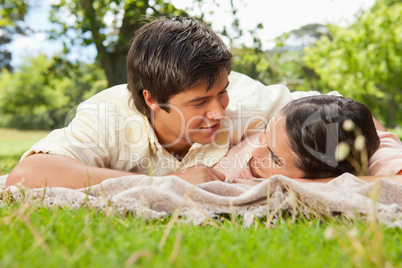 Two friends looking into each others eyes while lying on a blank