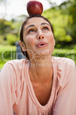 Woman balancing an apple on her head