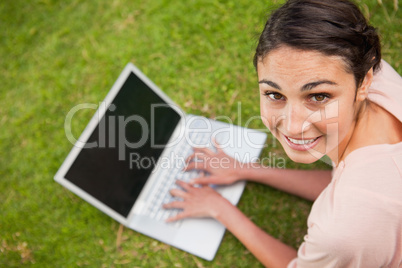 Woman looking to her side while using a laptop