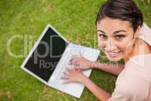 Woman looking to her side while using a laptop