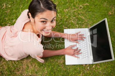 Woman looking upwards while using laptop