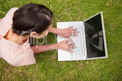 Elevated view of a woman using a laptop while lying down
