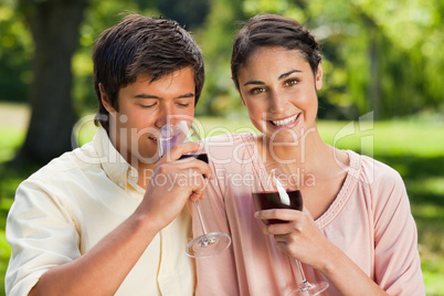Woman smiling while her friend is drinking wine