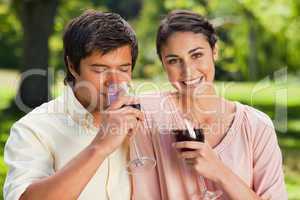 Woman smiling while her friend is drinking wine