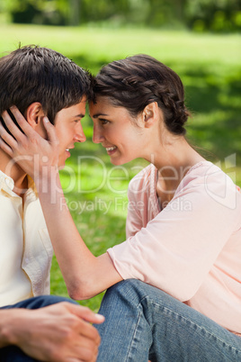 Woman looking at her friend while touching his head with her own