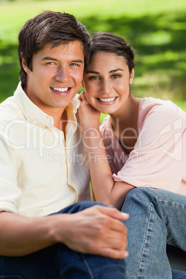 Woman leaning on her friend's shoulder while sitting with him