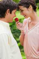 Man being offered a strawberry by his friend