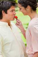 Woman feeding a strawberry to her friend