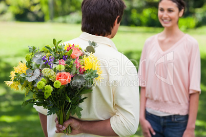 Man about to present a bouquet of flowers to his friend
