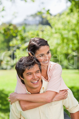 Woman smiling as she is getting a ride on her friends back