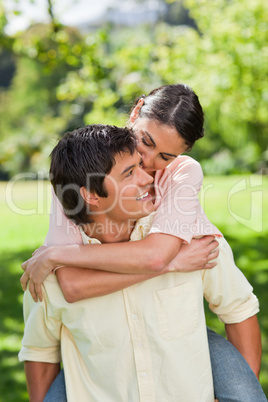 Man looking at his friend as he is carrying her on his back