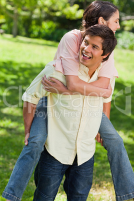 Man looking to his side while carrying his friend on his back