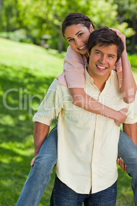 Woman with her hand on her friends head as he is carrying her