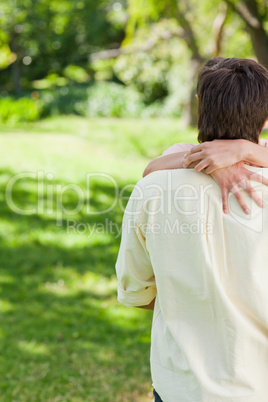 Man with his friends arms holding the back of his neck