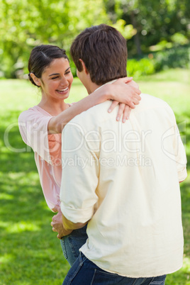 Woman laughing as she is holding onto her friend