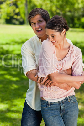 Woman laughing as she is being held around the waist by her frie