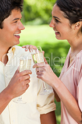 Two friends looking at each other while touching glasses of cham