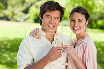 Two friends smiling while touching glasses of champagne