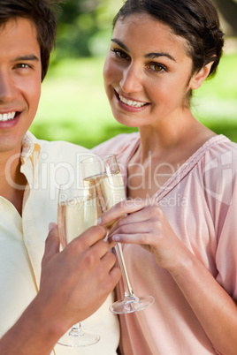 Woman smiling while touching glasses of champagne with her frien
