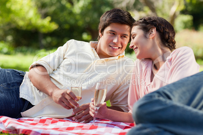 Man smiling as he looks at his friend during a picnic