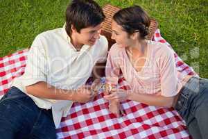 Two friends smiling towards each other during a picnic