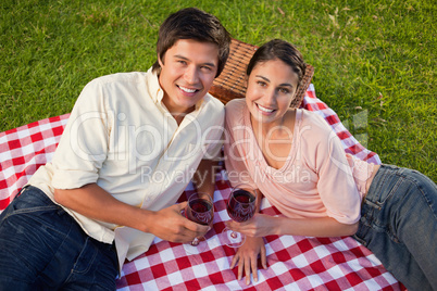 Two friends looking upwards while holding glasses of wine during