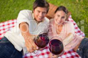 Two friends touching their glasses while raised during a picnic