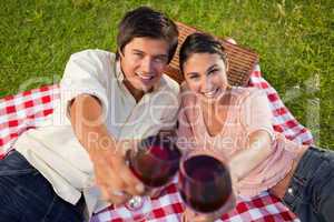 Two friends smiling as they touch their raised glasses during a