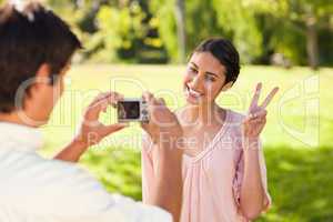 Man takes a photo of his friend giving the peace sign