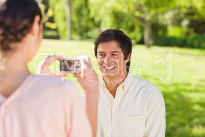 Woman takes a photo of her friend smiling