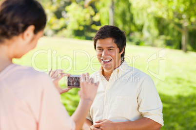 Woman takes a photo of her friend while hes laughing