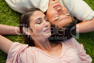 Man and a woman lying head to shoulder with their arm behind the