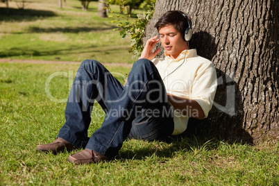 Man listening to music through headphones while resting