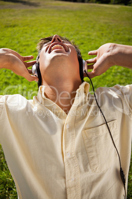 Man using headphones to sing along to music while sitting in gra