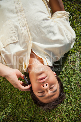 Man talks on the phone while lying on the grass