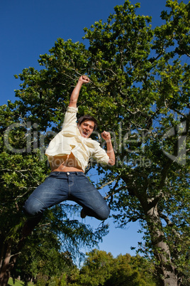 Man raising his arms and legs as he jumps in celebration