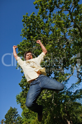 Man raising both of his arms and both of his legs as he jumps in