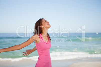 Young woman standing upright while sunbathing on the beach