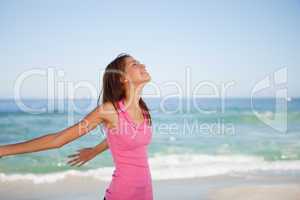 Young woman standing upright while sunbathing on the beach