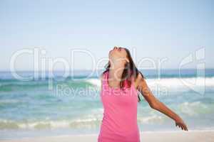 Young relaxed woman standing on the beach while sunbathing