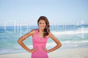 Young woman sunbathing while standing with hands on hips
