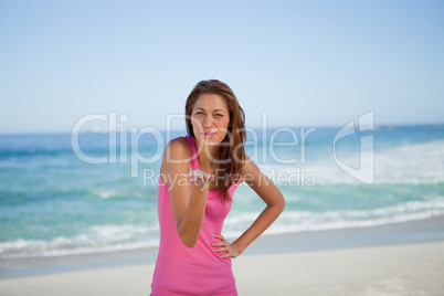 Young woman blowing an air kiss on the beach