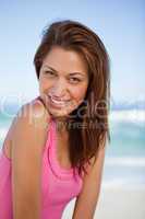 Young smiling woman looking at the camera while standing on the