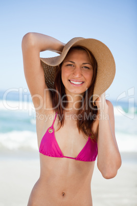Smiling teenager girl holding her hat with her hands