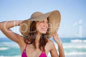 Smiling teenager standing in front of the sea while looking on t