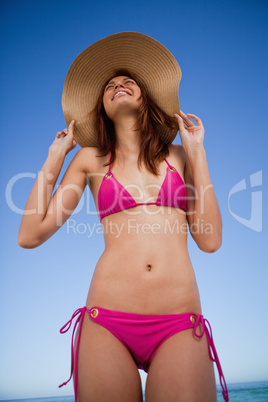 Low-angle view of a smiling teenager wearing a pink swimsuit