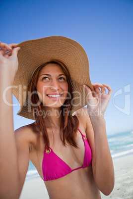 Smiling attractive teenager holding her hat brim in front of the
