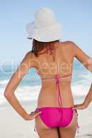 Back view of a beautiful teenager standing upright while looking
